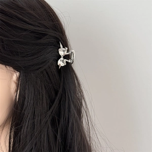 Close-up of heart-shaped crystal bow hair claw clip for a stylish side hairstyle