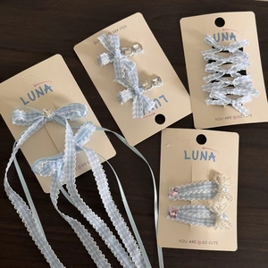 Blue gingham hair clip set with rhinestones and ribbon bows on a display card