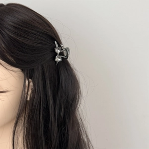 Mini butterfly hair claw clip with grey crystals on dark hair for elegant styling