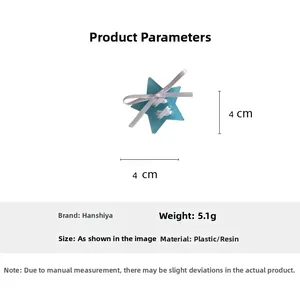 Teal star-shaped hair clip with pink ribbon bow detail and plastic resin finish