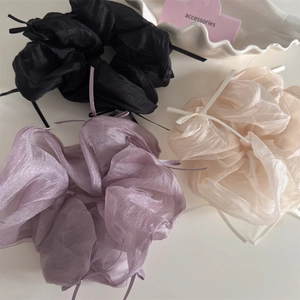 Three oversized organza scrunchies with ribbons in black, purple, and champagne gold