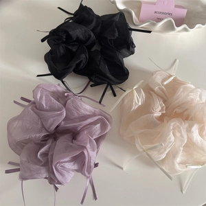 Detailed close-up of set of three organza ribbon bow scrunchies in pastel colors