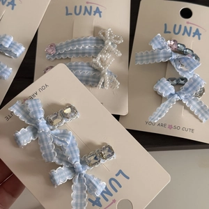 Blue plaid bow hair clips with pearls and rhinestones on a Luna display card
