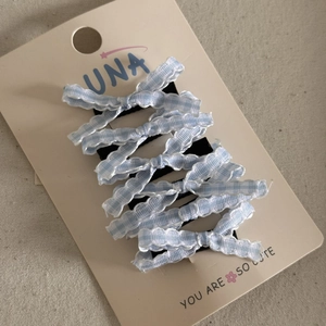 Detailed close-up of blue plaid bow hair clips with five pieces on display card