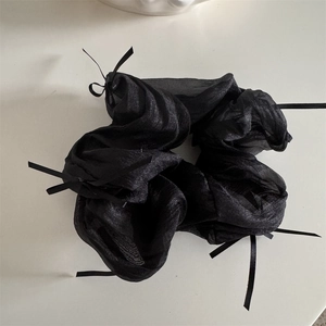 Detail shot of black mesh organza scrunchie with small ribbon bows in French ballet style