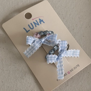 Detail of blue plaid bow hair clips with pink heart rhinestone on display card