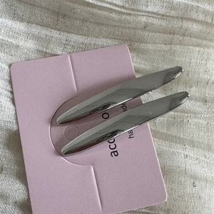 Gros plan de deux barrettes argentées brillantes en forme de fuseau sur carte rose