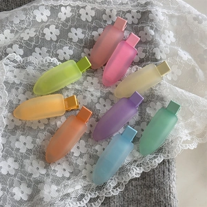 Vue détaillée de neuf pinces à cheveux en gelée mate colorée sur tissu en dentelle