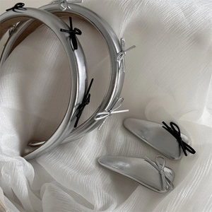 Silver leather bow headband and hair clips set on white fabric for chic styling
