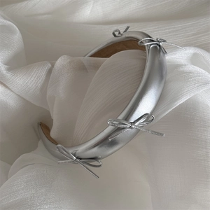 Detail showing silver metallic bow headband with soft brown non-slip velvet inner lining