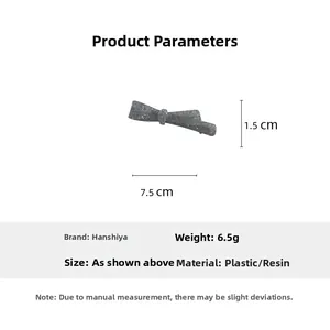 Detail showing a grey matte acetate bow hair clip with white spots and 7.5cm dimensions