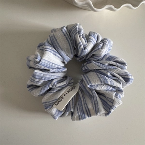 Detail of blue and white striped fabric scrunchie with a Made in Korea tag