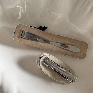 Detail of metal duckbill clip back with beige felt lining for secure hair grip