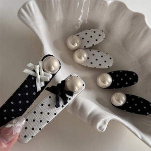 Polka dot fabric hair clips with white faux pearls and a bow on a shell plate