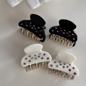 Set di quattro dolci mollette per capelli con strass colorati in nero e bianco crema