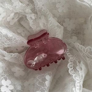 Dettaglio molletta per capelli rosa traslucida con pesciolini d'argento e bolle d'aria