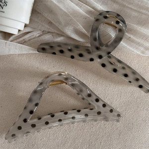 Detail of gray translucent polka dot hair claws with elegant gold metal springs