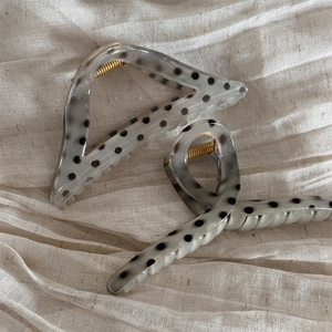 Triangle hair claw clip with black polka dots and gray marble texture on linen background