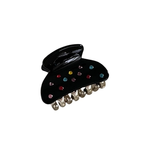 Pinza per capelli nera lucida con strass colorati su sfondo bianco