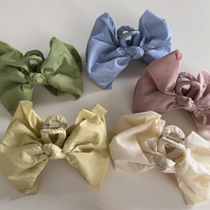 Set of large fabric bow hair claws in various pastel colors like sage green and dusty rose