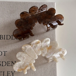 Detailed macro view of large acetate hair claws in tortoiseshell and pearly cream marble finish