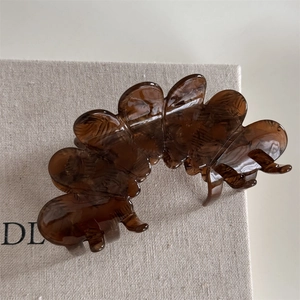Detailed close-up of large amber acetate flower hair claw clip with tortoise texture