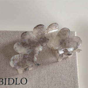Detailed macro of the acetate flower hair claw clip with a marble texture and petal design