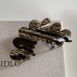 Close-up of elegant acetate hair claw clip with marble texture and strong grip design
