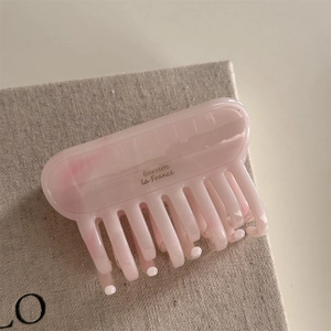 Gros plan sur la pince à cheveux en acétate rose marbré avec lettrage Barrette la France