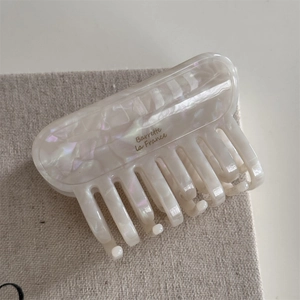 Détail de la pince à cheveux en acétate blanc nacré avec logo Barrette la France