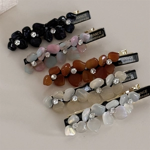 Macro shot of 5-piece floral duckbill hair clips with rhinestones and handmade engraving