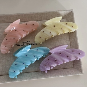 Close-up of marble pattern acetate hair claws with colorful rhinestones in four macaron shades