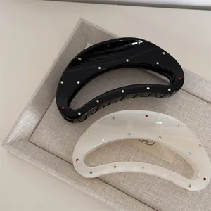 Polished crescent hair claws in black and white with colorful sparkling rhinestones