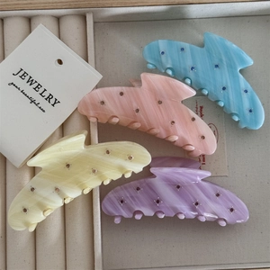 Detail of macaron acetate hair claws with marble texture and rhinestones in a gift box