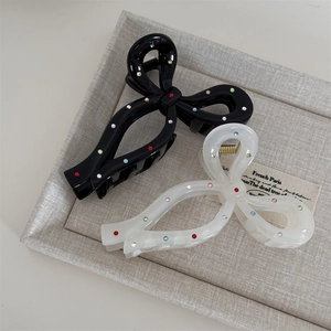 Detail of elegant black and white bow hair claws with colorful sparkling rhinestones