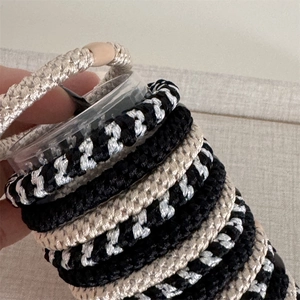 Close-up of thick braided high-elasticity hair ties in black and beige colors