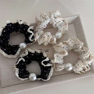 Detailed macro view of polka dot mesh hair ties with lace trim and large faux pearls