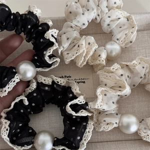 Close-up of mesh polka dot hair scrunchies with lace trim and elegant pearl accent