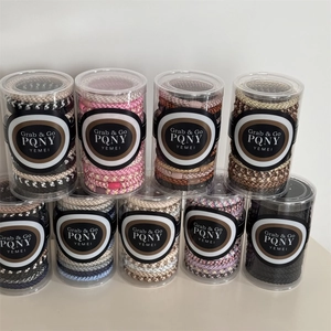 Nine plastic canisters of woven elastic hair bands in diverse colors and sleek packaging