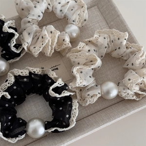 Macro detail of mesh polka dot hair scrunchies with lace trim and white pearls