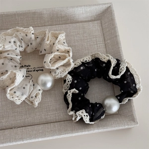 Detailed close-up of mesh polka dot scrunchies with lace trim and large pearls