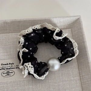 Detail of mesh polka dot scrunchie with lace edge and elegant pearl embellishment