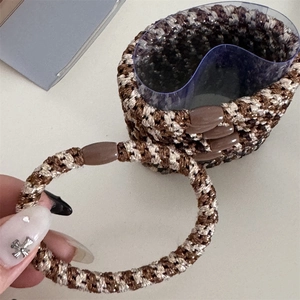 Detail of high-elasticity braided hair ties with brown houndstooth pattern and oval clasp