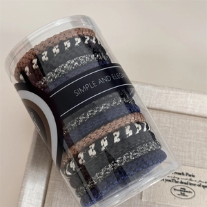 Detail of woven high-elastic hair ties in a clear cylinder jar with textured patterns