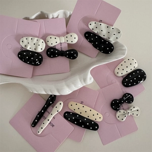 Close-up of black and white polka dot hair clips set on a stylish ceramic display tray