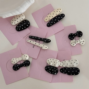 Chic black and white polka dot hair clips in bow and geometric shapes on pink display card