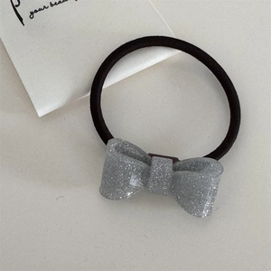 Detail eines glitzernden silbernen Pailletten-Haargummis mit schwarzem elastischem Band
