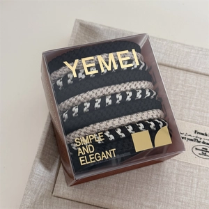 Detail view of 10 pack thick elastic hair ties in neutral colors inside premium box