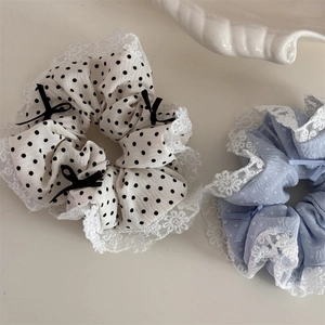 Gros plan de chouchous à pois avec bordures en dentelle et détails de nœuds doux