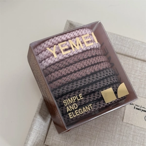 Detail of high-elastic braided hair ties in Morandi colors inside a clear gift box